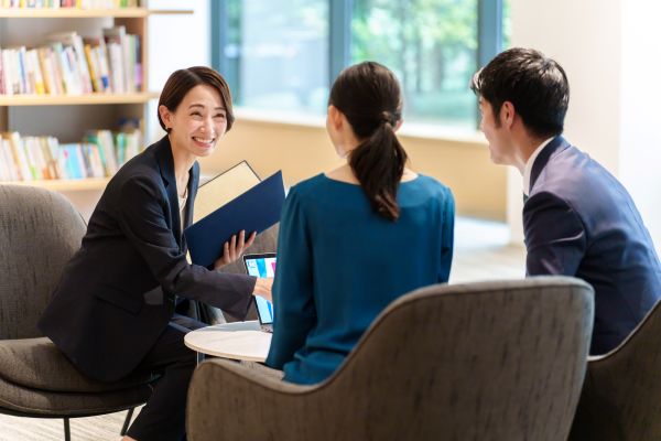 REALTY ONEのスタッフが、土地活用と相続に関するご相談に見えたご夫婦に、専門的なアドバイスを丁寧に行っている様子。